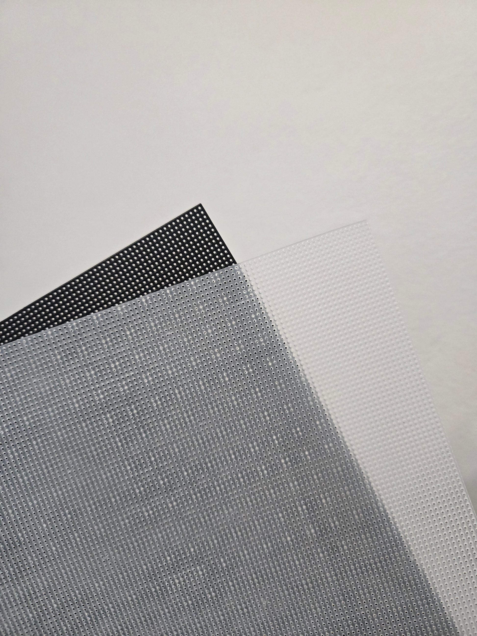 Two sheets of plastic canvas 14Ct, one black and one clear.